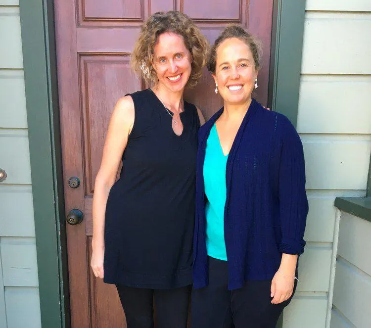 Robin McKenna and Della Duncan standing in front of a door