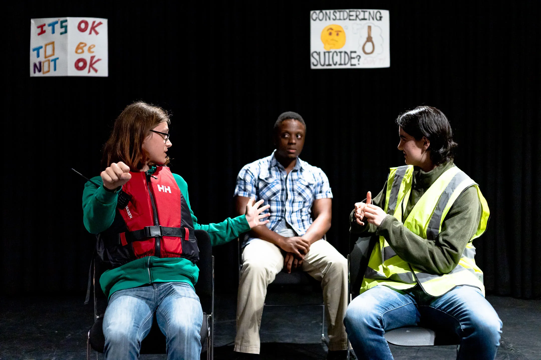 Three boys performing a play on stage. 