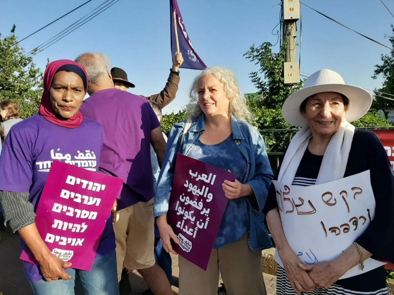 Three people holding placards.