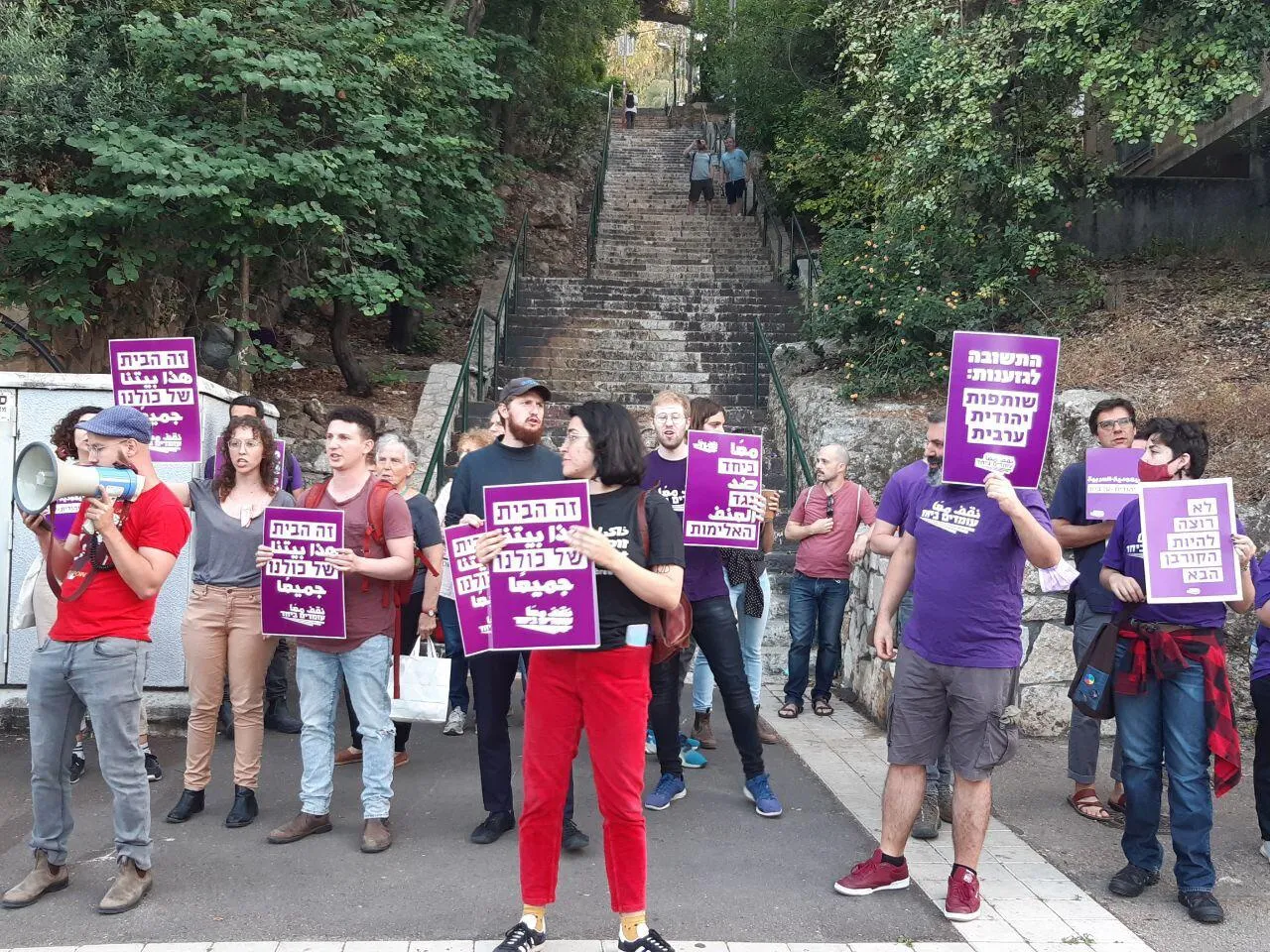 People with placards gathered at the base of some stone steps