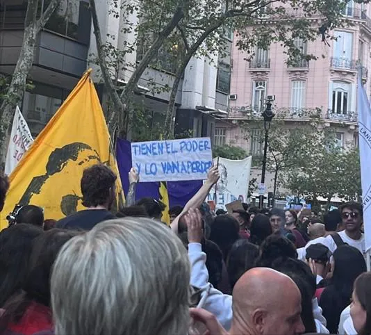 A person in a protest holding a sign that says “They have the power but they are going to lose it”