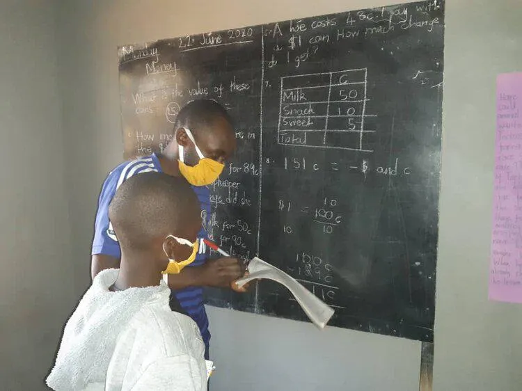 A teacher and student at a blackboard