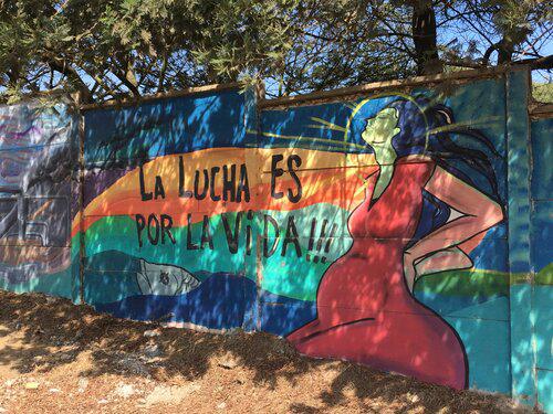 A brigthly coloured wall mural in Ventana, Puchuncaví city, Chile, representing the community and  socio environmental conflict earth future