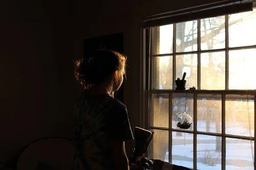 A person looks out through sash windows