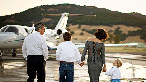 A family walk towards a private jet