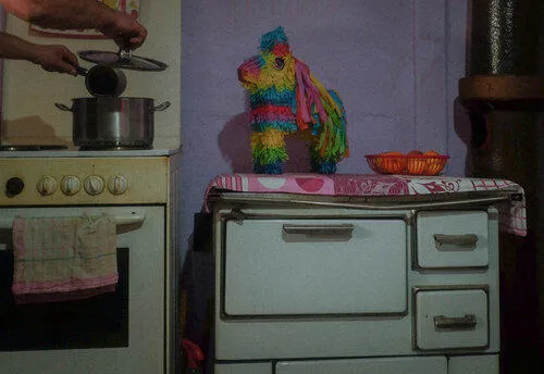 A brightly coloured piñata near in a kitchen