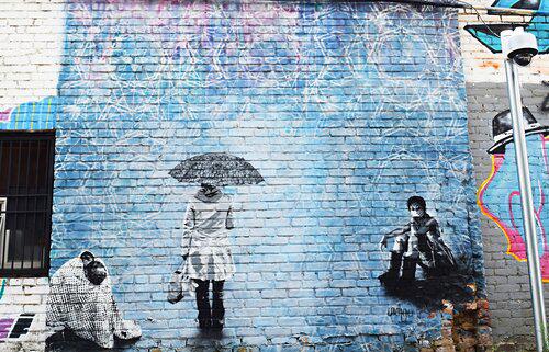 A painting of a woman holding an umbrella on a wall