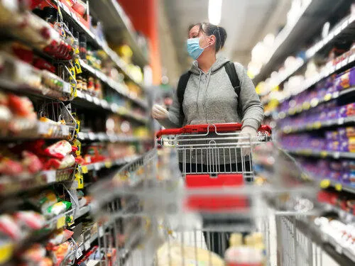 A person looking at food in a supermarket aisle