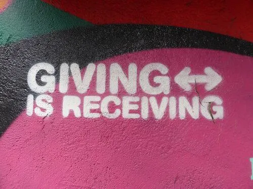 "Giving is receiving" graffitied onto a wall