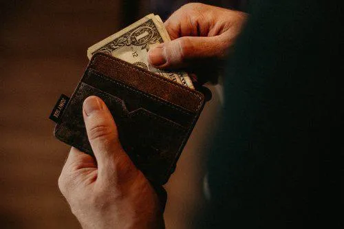 A person taking money from their wallet