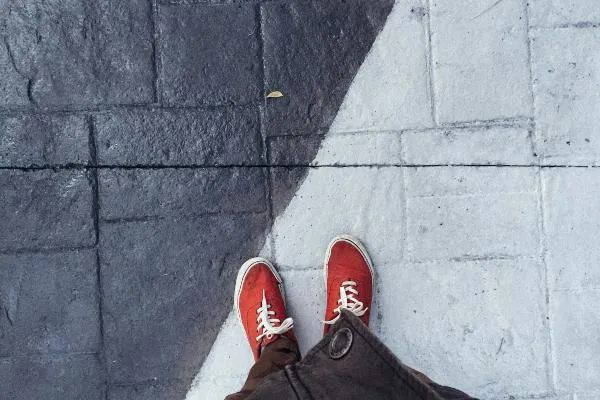 Person standing on the line between grey and white concrete floor