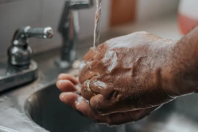 Hands being washed under tap