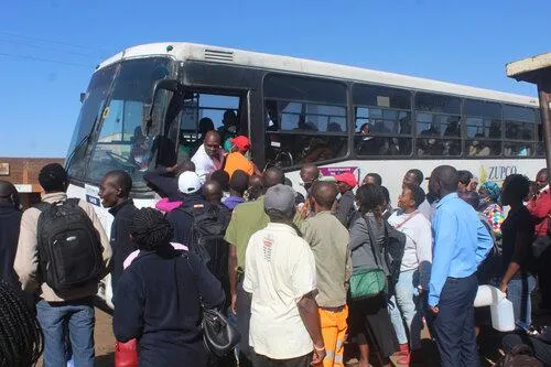 Many people waiting to get on a waiting bus