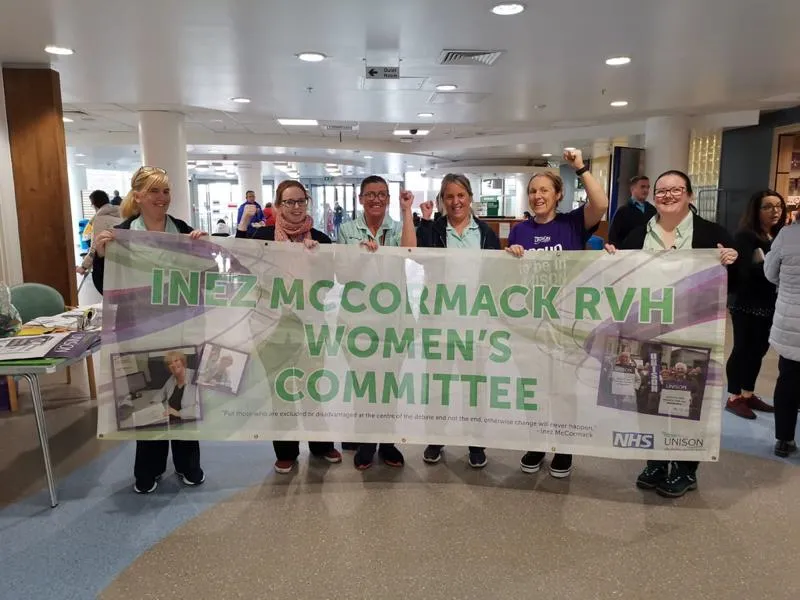 Women hoilding a banner that says "Inez Mccormack RVH Women's Committee"