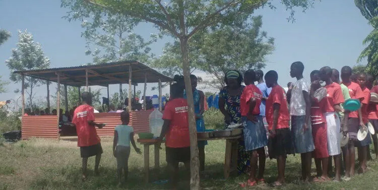 Several schoolchildren gathering outside near a tree