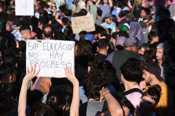 Group of people in a protest with a sign that says "Sin educasion no hay progreso"