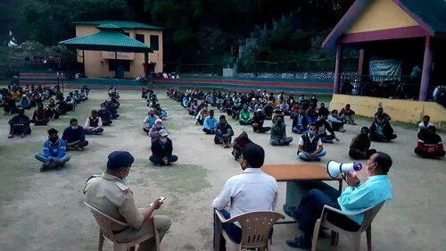 Many people sitting down in a large arena