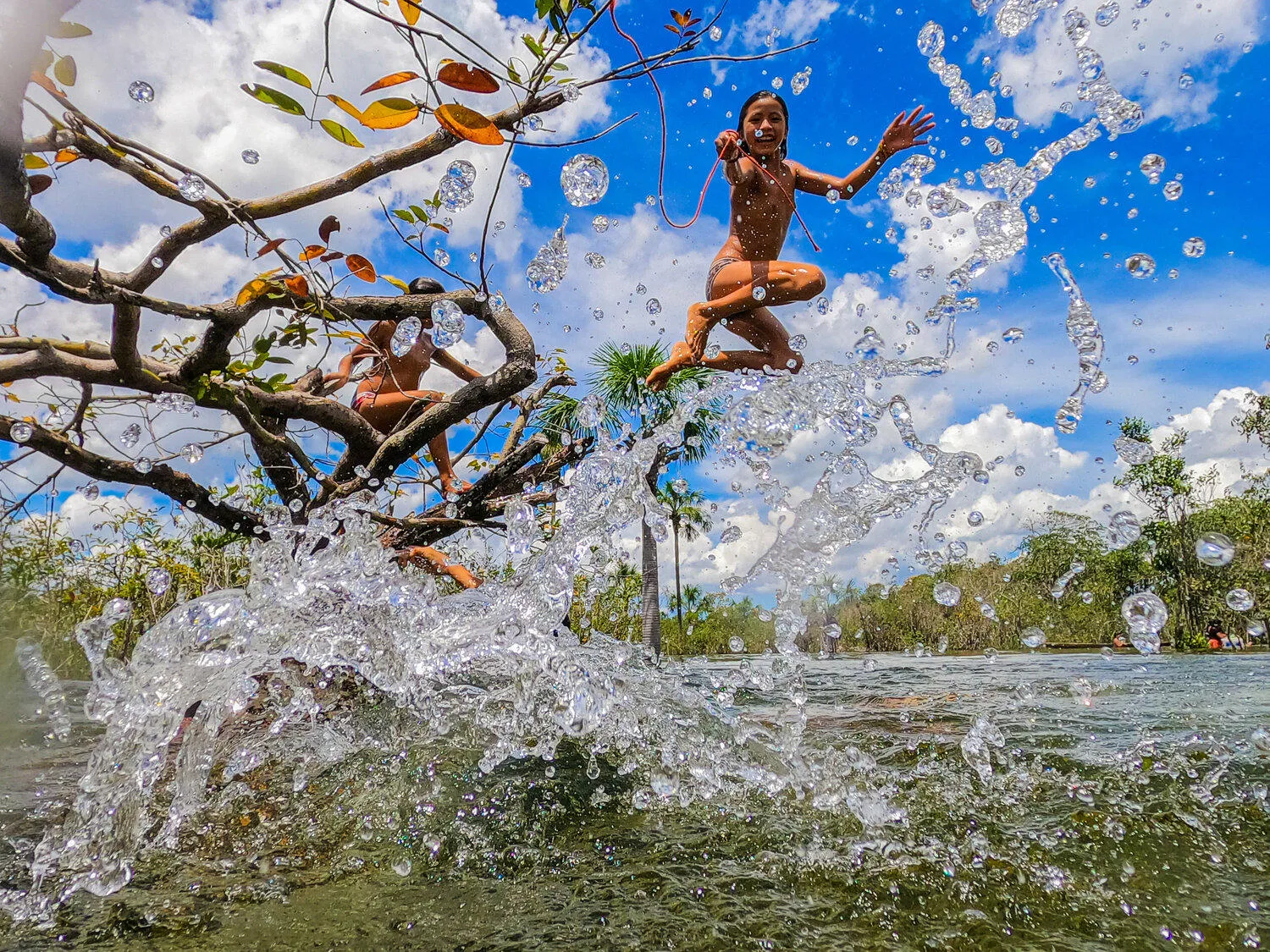 Children leaping from a river bank into the water