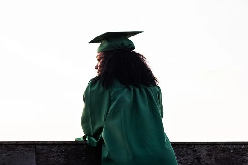 A graduate looking away over a balcony