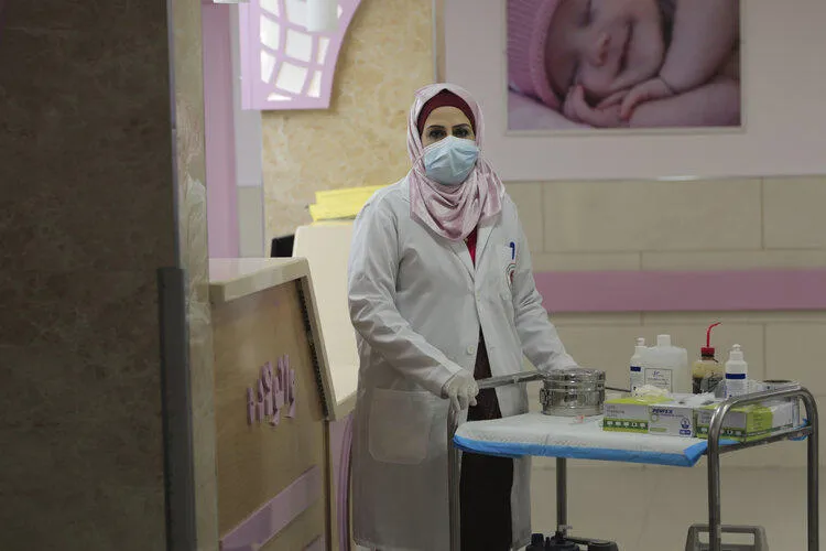 A care worker standing next to a tray of hospital equipment