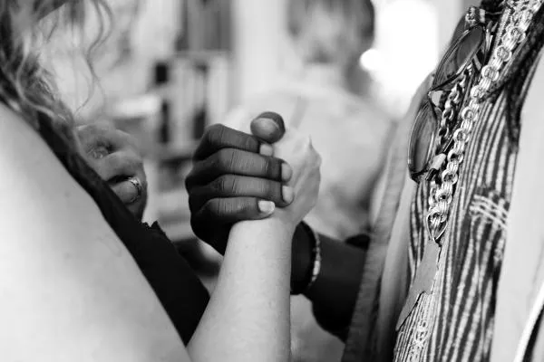 Black and white image of two people holding hands