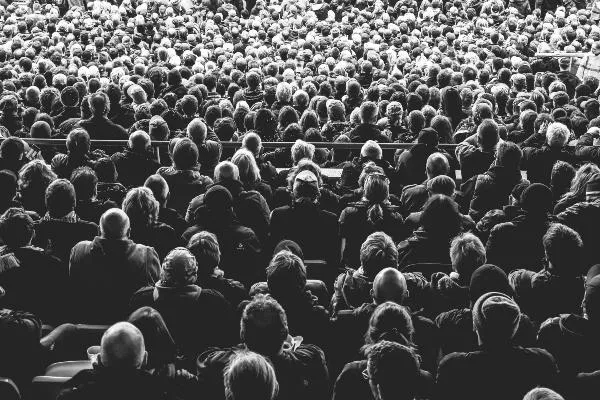 black and white image of a crowd of people sitting down