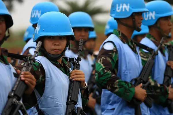 Group of UN peacekeepers wearing blue helmets and carrying weapons