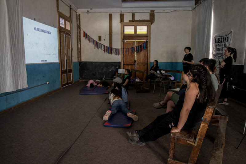 Group of people watching a film projected on the wall