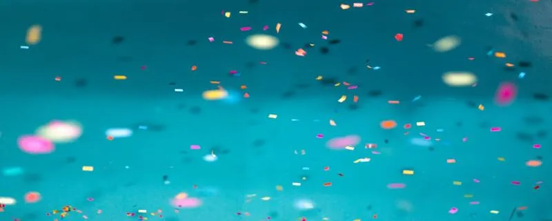 An image of colourful confetti over a blue background. 