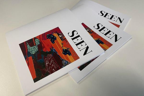 Pile of artbooks with the title 'SEEN' and an abstract image