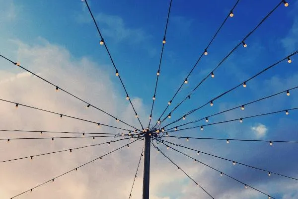 Wires with lightbulbs coming together at a mast