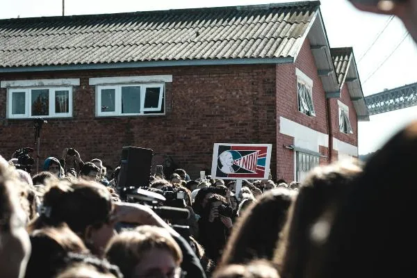 Crowd of protesters in front of a brick building