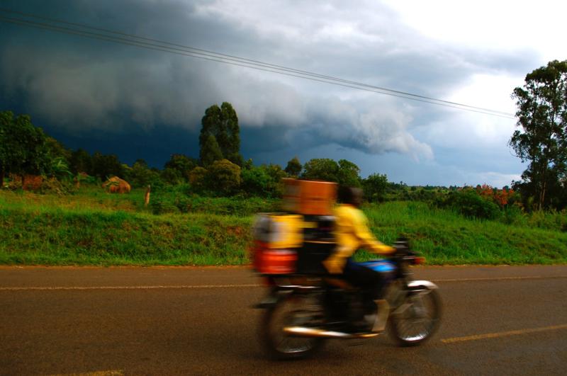 Person delivering goods on a motorcycle in rural Uganda